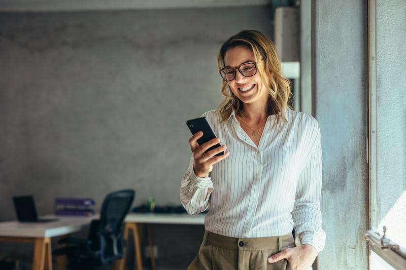 businesswoman looking at phone and smiling